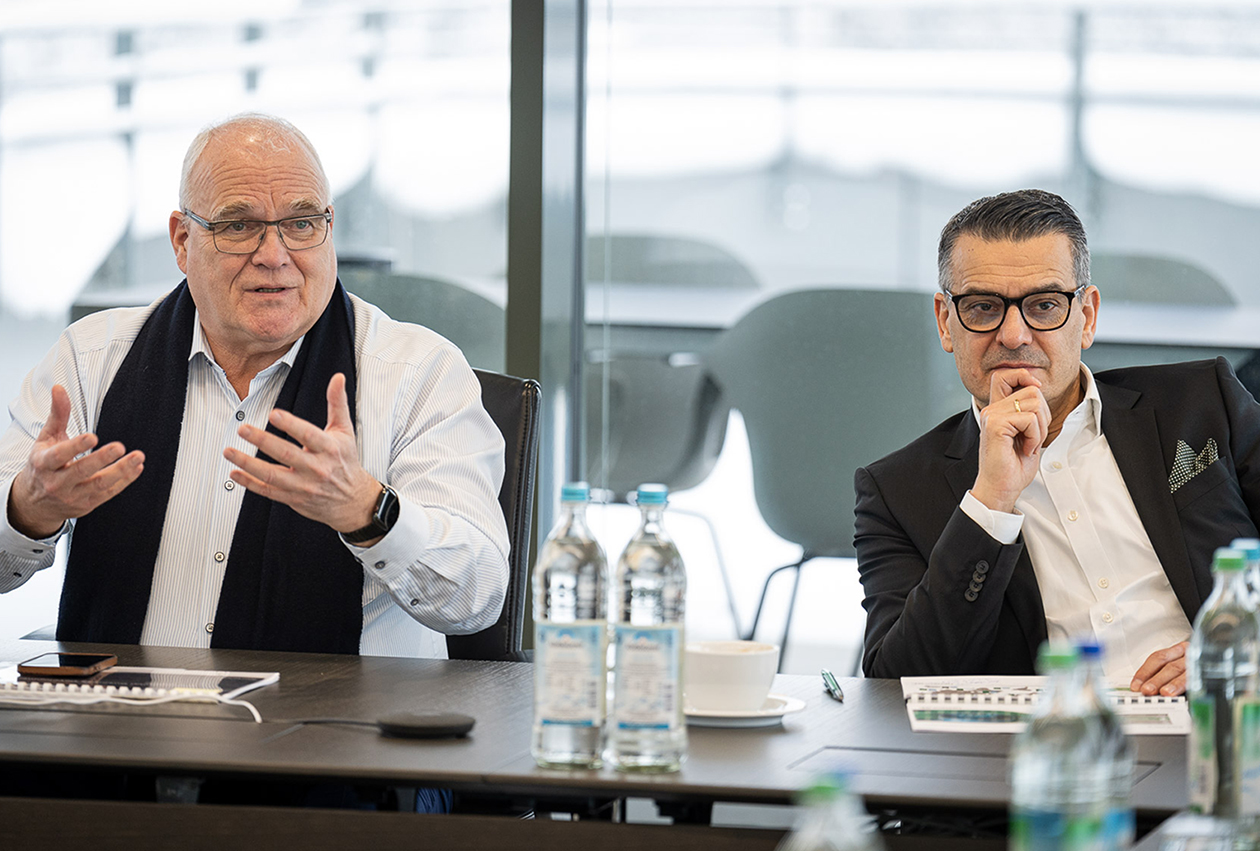 Foto von Thomas Müller und Oliver Dörre, die an einem Konferenztisch sitzen